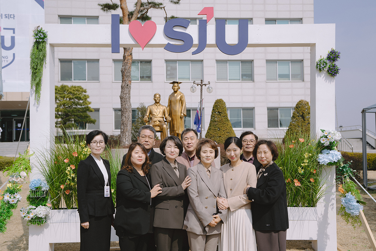 학교 동상 앞에서 단체사진을 찍고 있다2